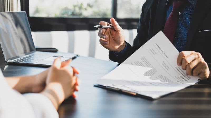 Corretor e comprador analisam as certidões para compra de imóvel