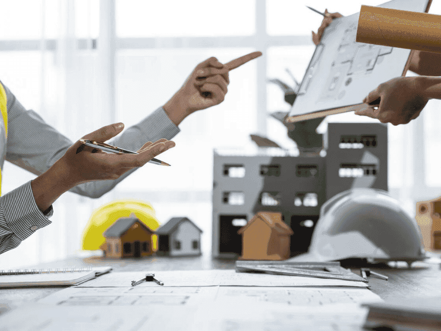 Profissionais do setor imobiliário analisando plantas e maquetes de empreendimento, representando a aplicação estratégica da lei de incorporação imobiliária na viabilidade do projeto.