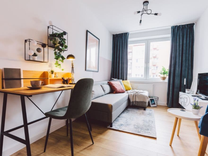 Interior de uma tipologia de apartamentos estilo studio com sala de estar e home office integrados.