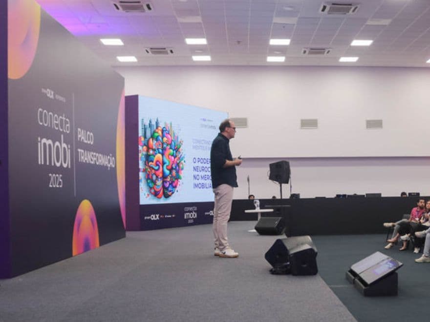 César Gimenez apresentando a palestra no Conecta Imobi 2025 para profissionais do mercado imobiliário e neurociência.