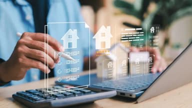 orretor de imóveis realizando análise digital de matrícula e débitos propter rem em um notebook.